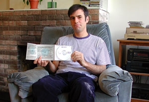Josh McCue shows off the liner notes to <i>Opium Of The Masses.